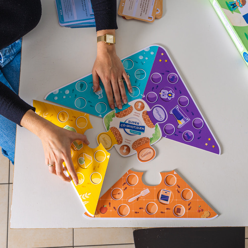 Parents et enfants jouant à Super Co-quotidien, un jeu éducatif qui renforce les compétences d’autonomie tout en passant des moments ludiques en famille. Jeu éducatif