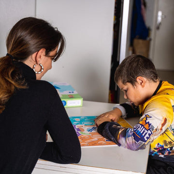Enfants jouant avec Super Co-quotidien, Mini-quotidien École, Cartes Petit Héros et Tableau de routine magnétique, développant leur motricité, leurs compétences cognitives et sociales.