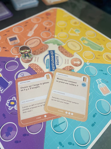 Famille jouant ensemble avec Super Co-quotidien, Mini-quotidien École, Cartes Petit Héros et Tableau de routine magnétique, partageant des moments de complicité et de développement des enfants.